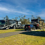 View of Class A RV, level RV site with full hookups and picnic table at The Station RV Resort in Madison, FL