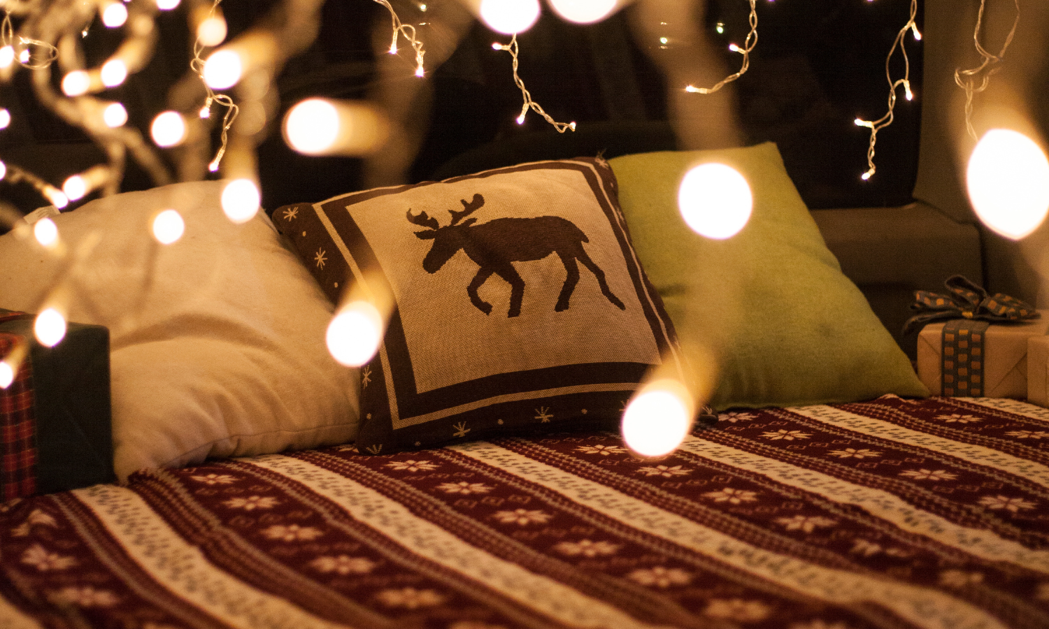 Cozy holiday RV trip decorated space with twinkle lights and festive bedspread