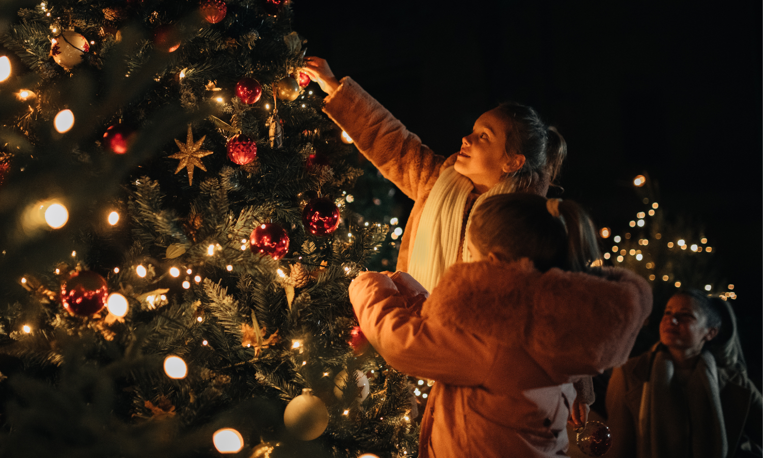 Children admiring a Christmas tree at a festive tree lighting event.