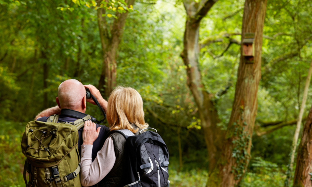 RV travelers birdwatching in a wooded area in Central Georgia during a spring stay at Twin Oaks RV Park.
