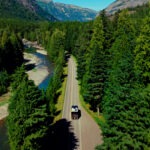 An RV cruising through the beautiful, forested roads of Western Montana on a road trip.