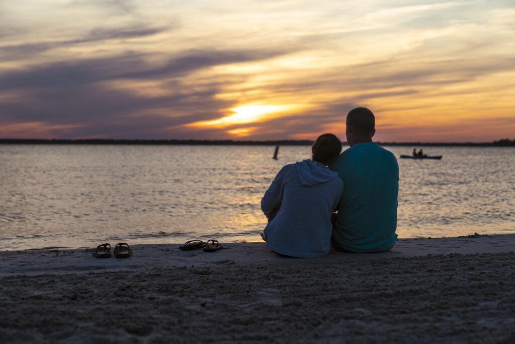 Couple on the Beach enjoying Sunset at North Landing Beach RV Resort & Cottages