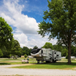 RV traveler enjoying a shaded campsite beneath mature trees at Rivertown Rose Campground in Vicksburg, Mississippi.