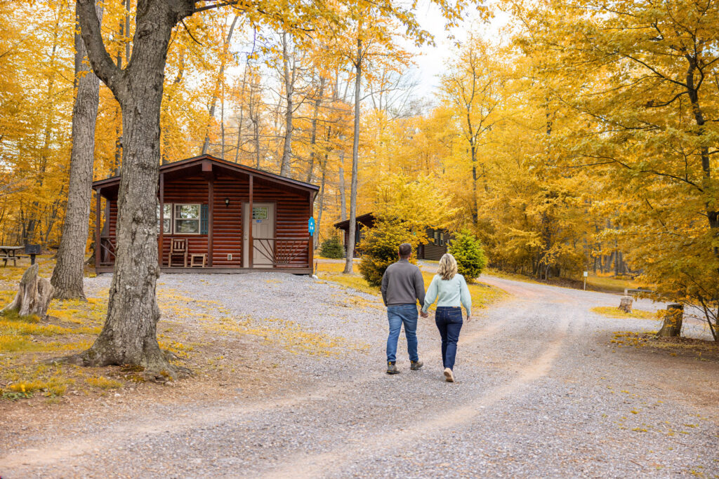 A couple walking through the fall foliage at Twin Grove RV Resort & Cottages in Pennsylvania