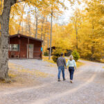 A couple walking through the fall foliage at Twin Grove RV Resort & Cottages in Pennsylvania
