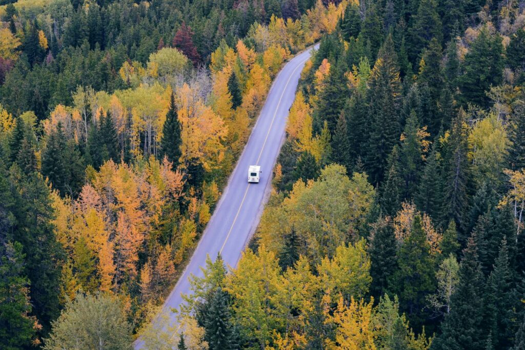 RV driving through beautiful fall foliage on a road trip across the states.