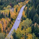 RV driving through beautiful fall foliage on a road trip across the states.